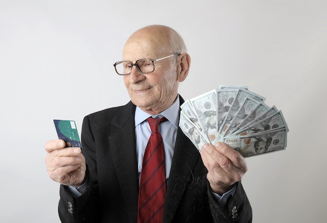a man holding cash and a credit card